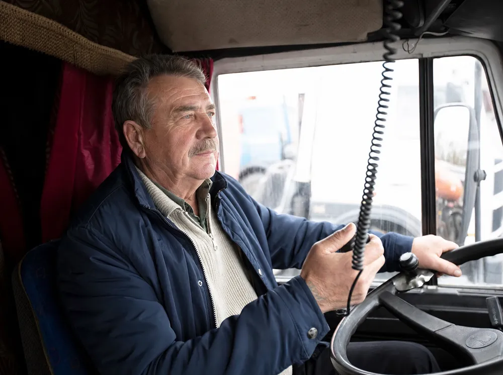 Ervaren vrachtwagenchauffeur achter het stuur, Code 95 actualisatie kennis vakbekwaamheid